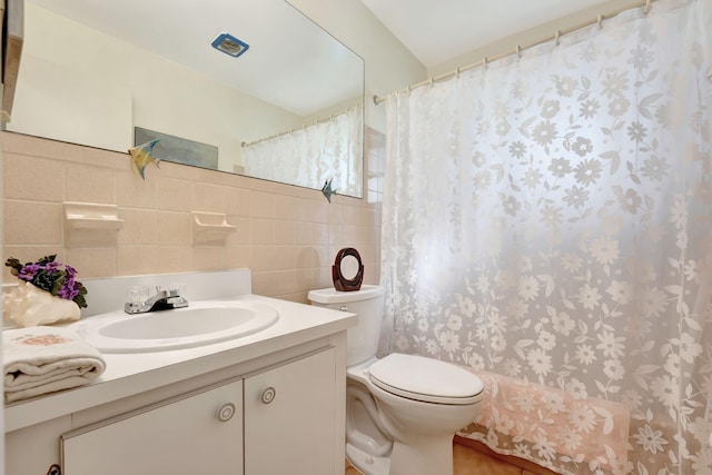 bathroom featuring tile walls, vanity, toilet, and walk in shower