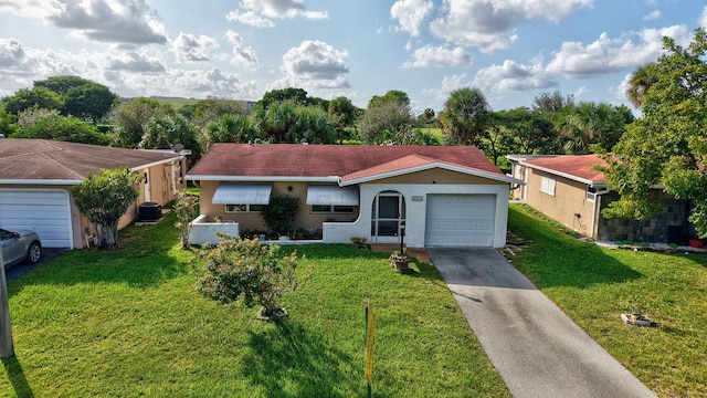 ranch-style home featuring a front yard, central AC, and a garage