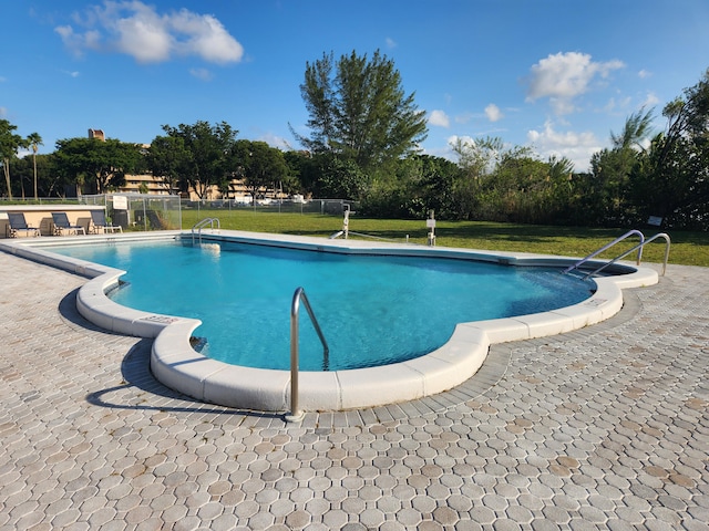 view of swimming pool with a patio area and a lawn