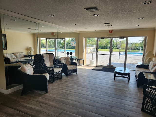 living room featuring crown molding, hardwood / wood-style flooring, and a textured ceiling