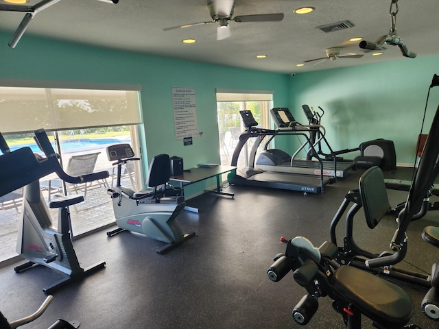 gym featuring a textured ceiling and ceiling fan