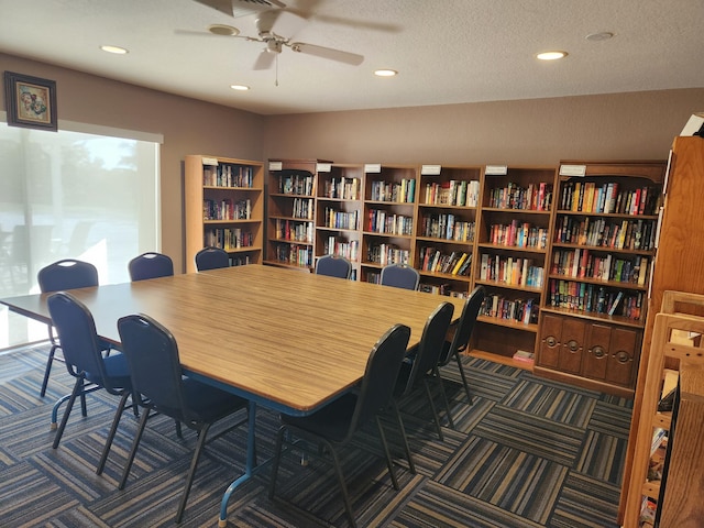 carpeted office space featuring a textured ceiling and ceiling fan