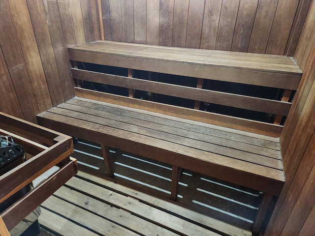 view of sauna with wooden walls and wood-type flooring