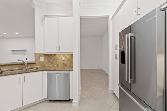 kitchen featuring dark stone counters, sink, white cabinets, and stainless steel appliances