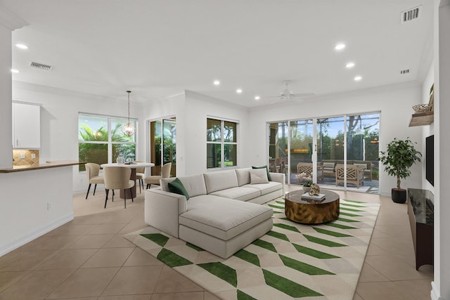 living room with ceiling fan, light tile patterned flooring, and ornamental molding