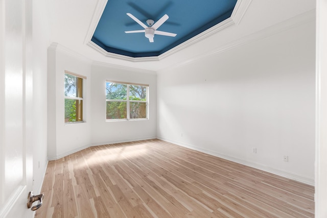 unfurnished room with ornamental molding, a tray ceiling, ceiling fan, and light hardwood / wood-style floors