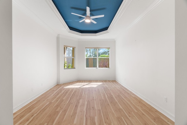 unfurnished room featuring ornamental molding, a tray ceiling, ceiling fan, and light hardwood / wood-style floors