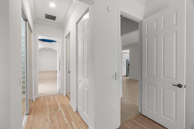 hallway featuring light wood-type flooring and ornamental molding