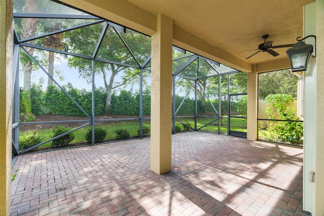 unfurnished sunroom with ceiling fan