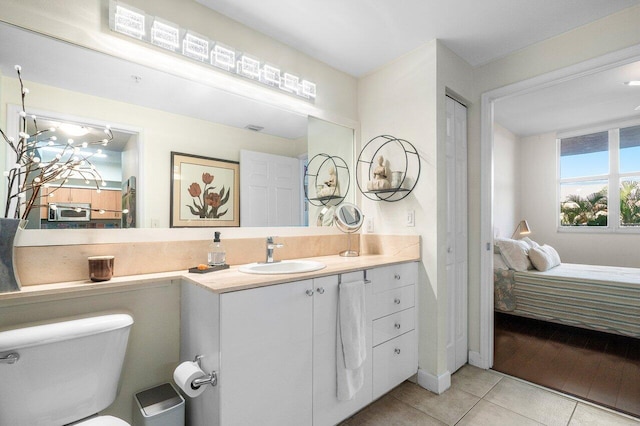 bathroom featuring tile patterned flooring, vanity, and toilet