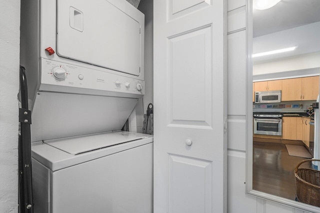 clothes washing area with stacked washer and clothes dryer