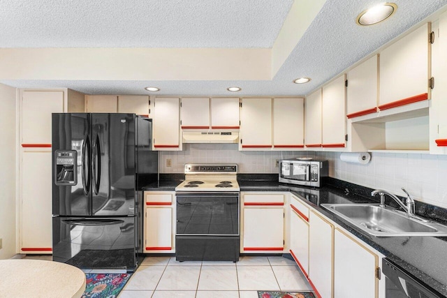 kitchen featuring sink, appliances with stainless steel finishes, cream cabinets, and light tile patterned flooring