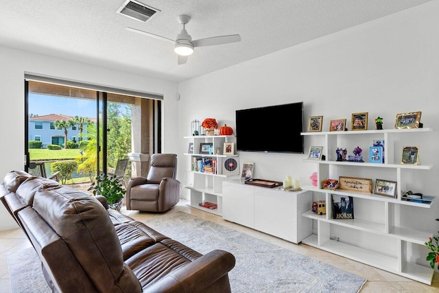 tiled living room with a textured ceiling and ceiling fan