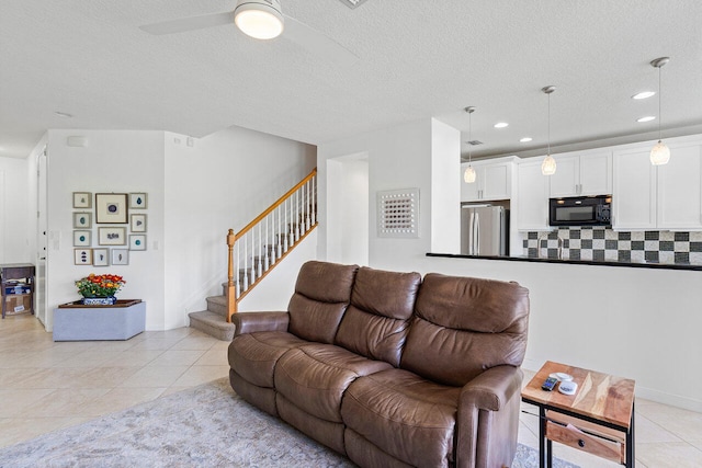 tiled living room featuring ceiling fan and a textured ceiling