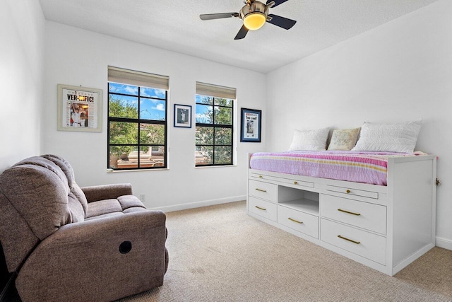 carpeted bedroom featuring ceiling fan and a textured ceiling