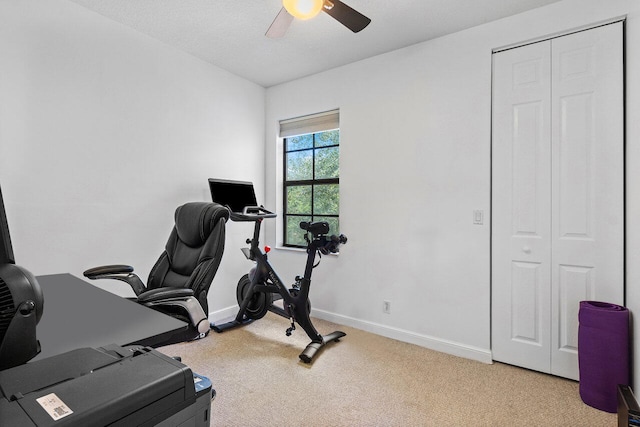 workout room with ceiling fan and light colored carpet