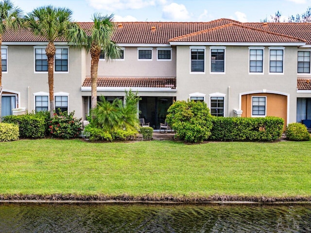 rear view of property featuring a yard and a water view