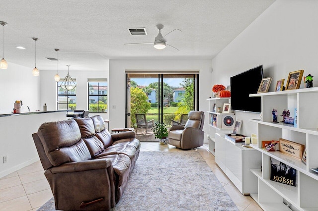 tiled living room featuring ceiling fan and a textured ceiling