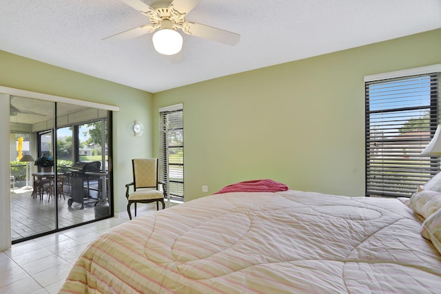 tiled bedroom with ceiling fan, access to outside, and a textured ceiling