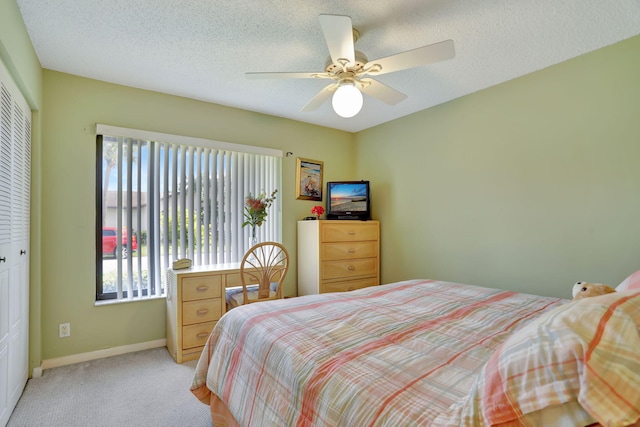 carpeted bedroom featuring a textured ceiling, a closet, and ceiling fan