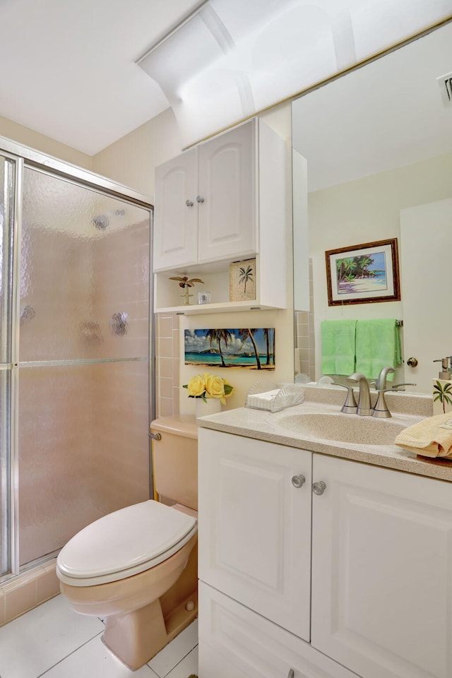 bathroom featuring toilet, walk in shower, vanity, and tile patterned flooring