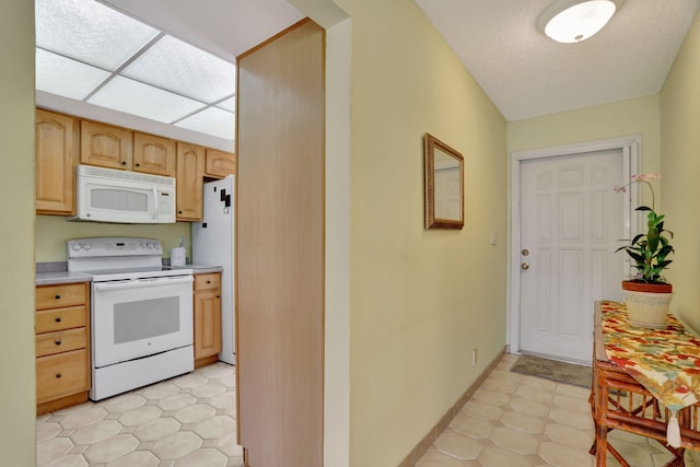 kitchen featuring light brown cabinetry and white appliances