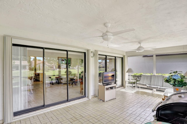 sunroom / solarium with a healthy amount of sunlight and ceiling fan