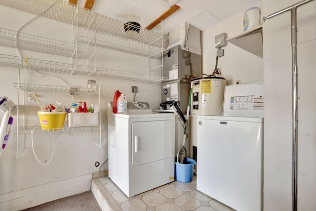 laundry room featuring water heater, washing machine and clothes dryer, and light tile patterned floors