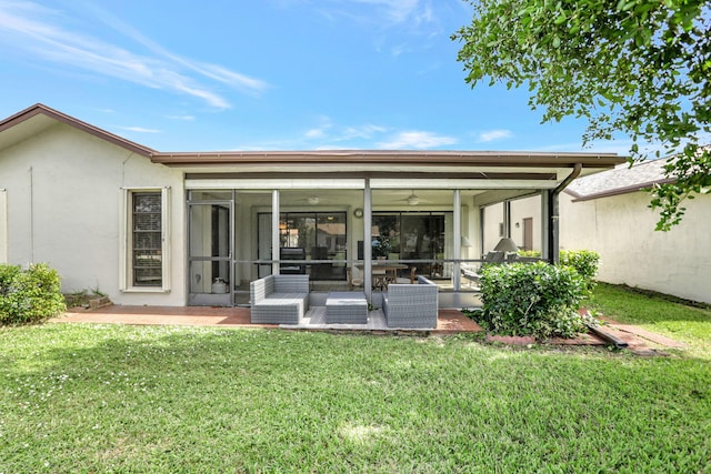 rear view of property featuring a yard, a patio, and a sunroom