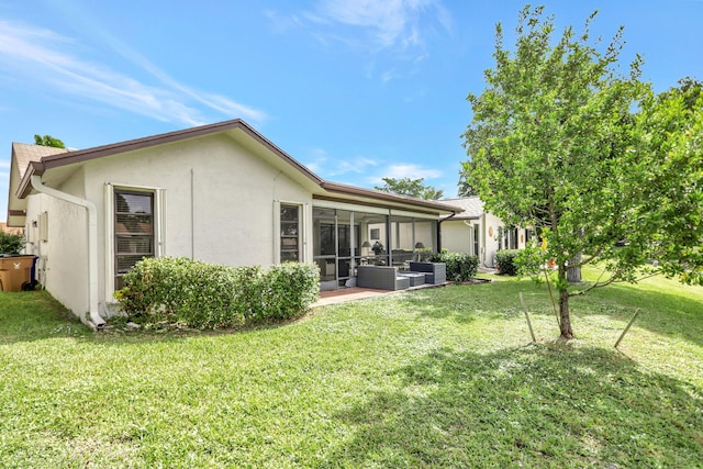 back of house featuring a patio area, an outdoor living space, a lawn, and a sunroom