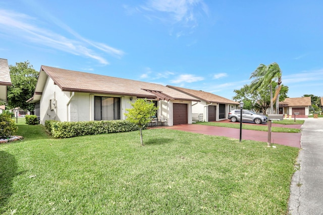 ranch-style house featuring a front lawn and a garage