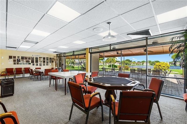 rec room with a paneled ceiling and carpet flooring