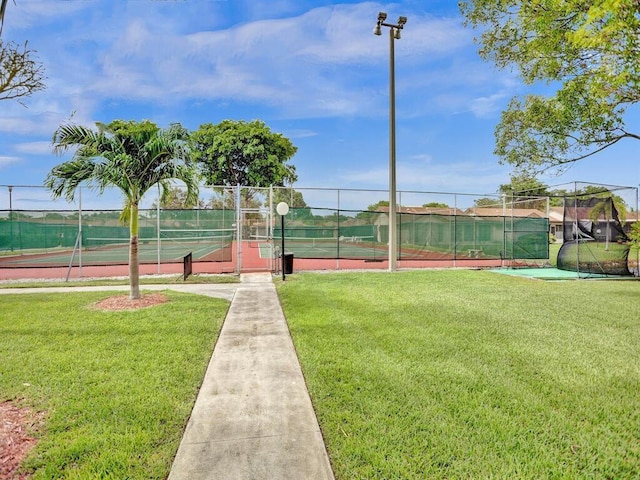 view of tennis court featuring a yard