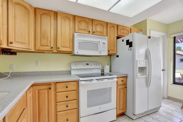 kitchen with light tile patterned flooring and white appliances