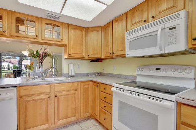 kitchen featuring sink, light tile patterned floors, and white appliances