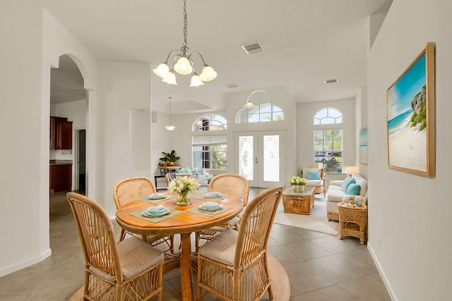 dining room with a chandelier, a wealth of natural light, french doors, and light tile patterned floors