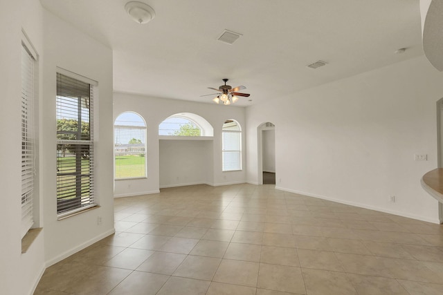 spare room with ceiling fan, light tile patterned floors, and a healthy amount of sunlight