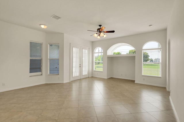 tiled spare room featuring french doors and ceiling fan