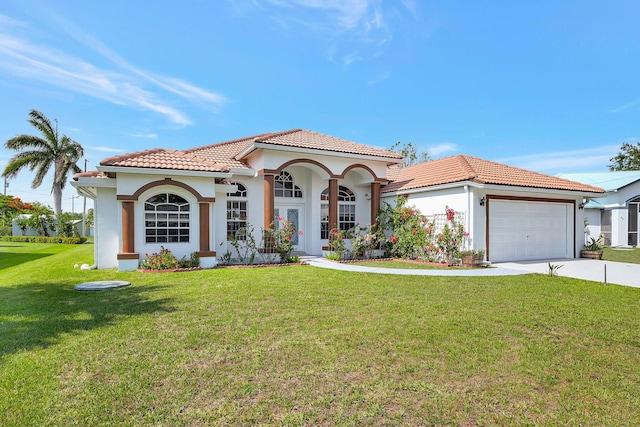 mediterranean / spanish home featuring a front lawn and a garage