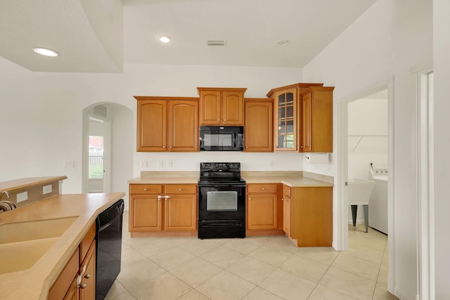 kitchen with black appliances, sink, and light tile patterned floors