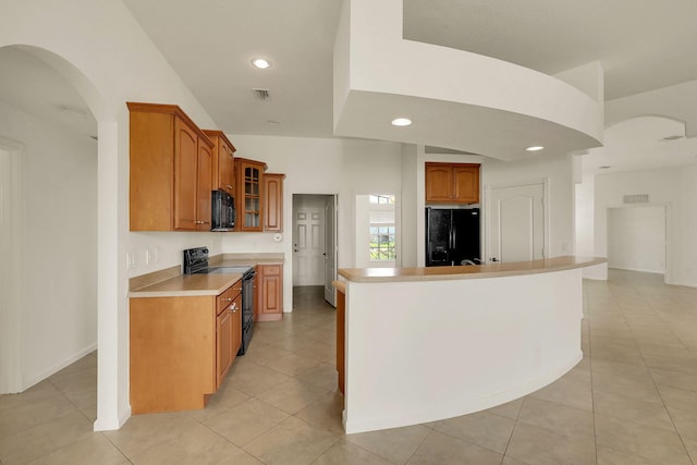 kitchen featuring black appliances, light tile patterned floors, and a center island