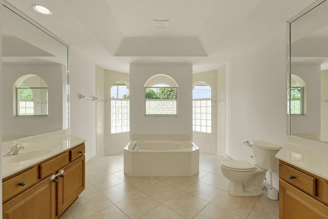 bathroom with a relaxing tiled tub, a wealth of natural light, and tile patterned flooring