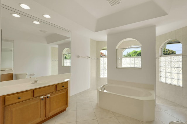 bathroom featuring vanity, tile patterned floors, and a tub