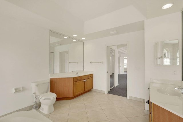 bathroom with toilet, vanity, and tile patterned flooring