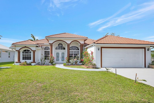 mediterranean / spanish-style home with a garage, a front lawn, and french doors