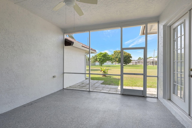 unfurnished sunroom featuring ceiling fan