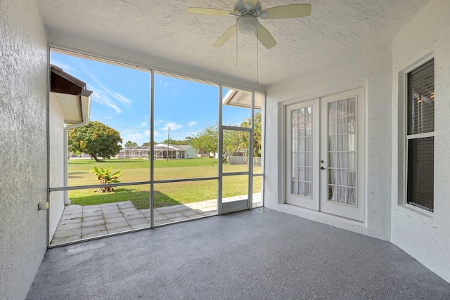 unfurnished sunroom with ceiling fan and french doors