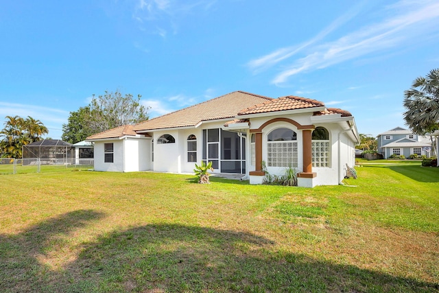 rear view of house with a lanai, a sunroom, and a yard