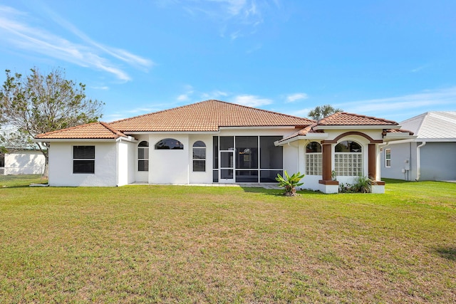 rear view of property featuring a lawn and a sunroom