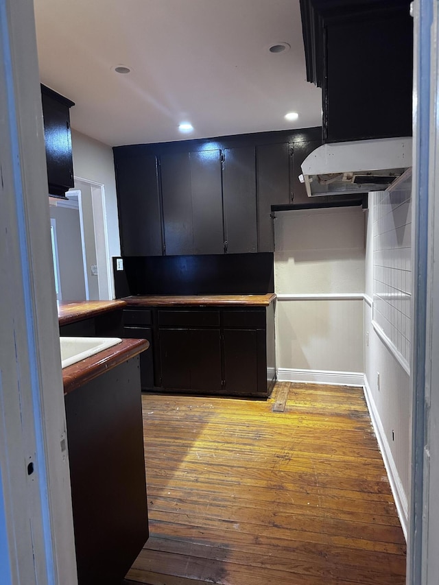 130 NE 4th Ave, Boynton Beach, FL 33435 - kitchen with dark cabinetry, light wood-style flooring, and recessed lighting